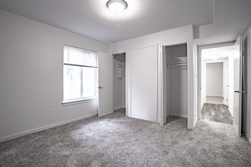 carpeted bedroom with door leading to hallway