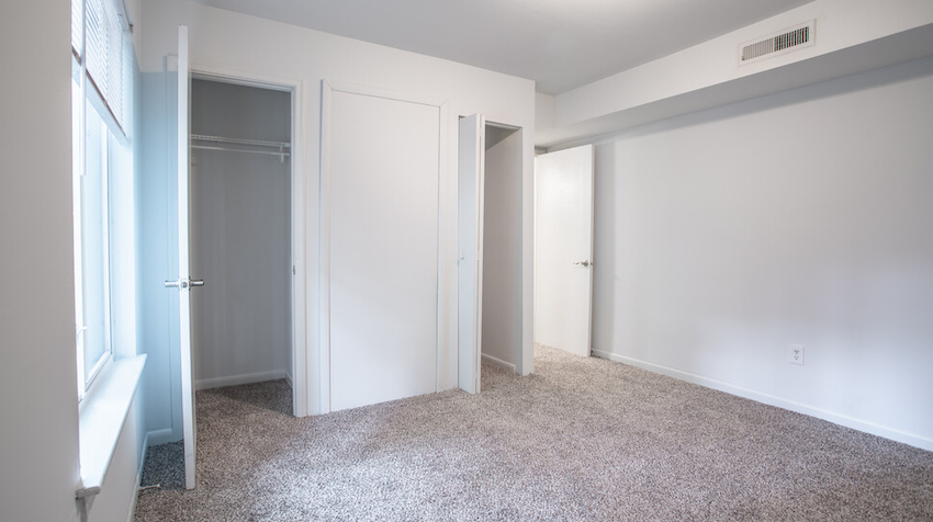 carpeted bedroom with two doors to closets